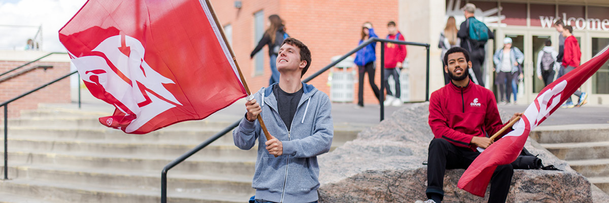 a student waving a flag in front of a crowd
